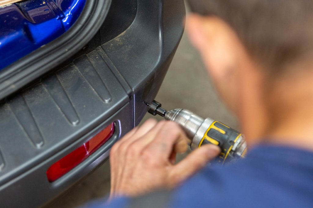 A parking sensor being fitted