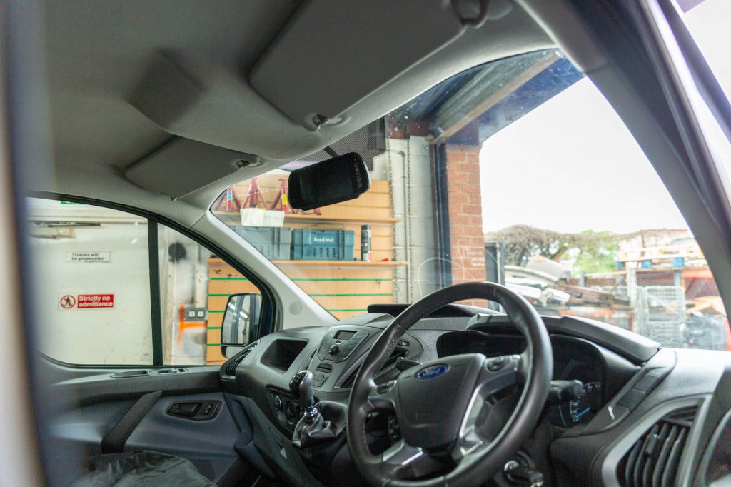 A dash camera fitted to the windscreen of a van