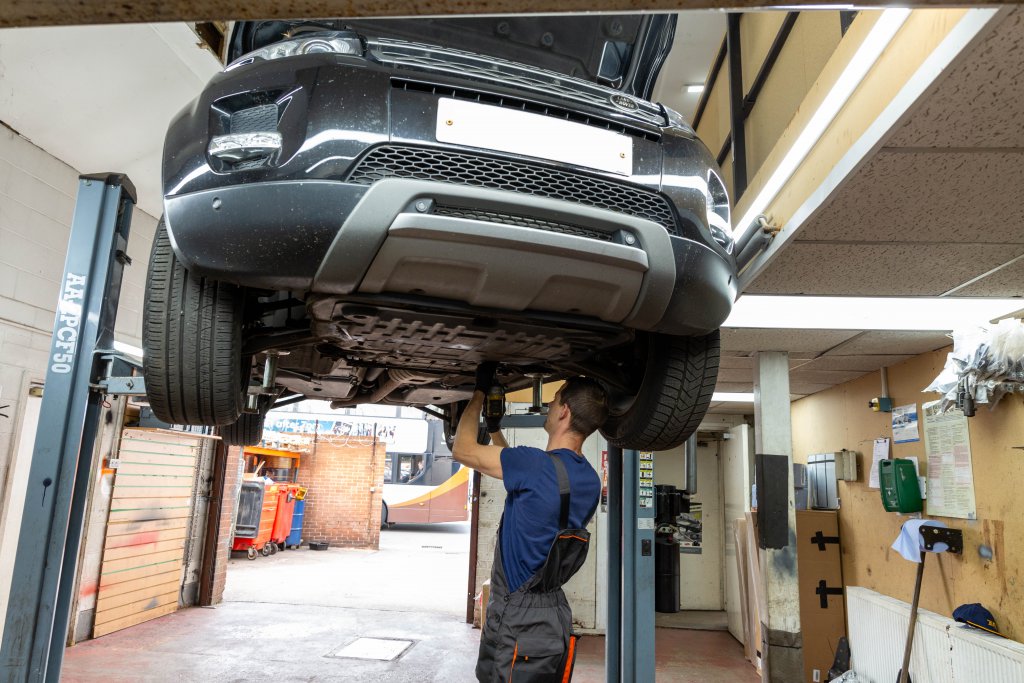 A car raised on the ramp for brake work at Ken’s Auto Spares